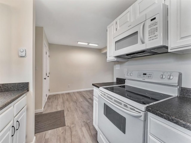 1565 Shadow Run Frontage Unit 104, Steamboat Springs, CO 80487 - kitchen with white appliances, dark countertops, white cabinets, and light wood-style floors