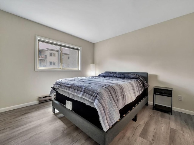 1565 Shadow Run Frontage Unit 104, Steamboat Springs, CO 80487 - bedroom with baseboards, wood finished floors, and a baseboard radiator