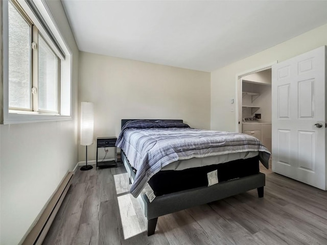 1565 Shadow Run Frontage Unit 104, Steamboat Springs, CO 80487 - bedroom with separate washer and dryer, a baseboard heating unit, and wood finished floors