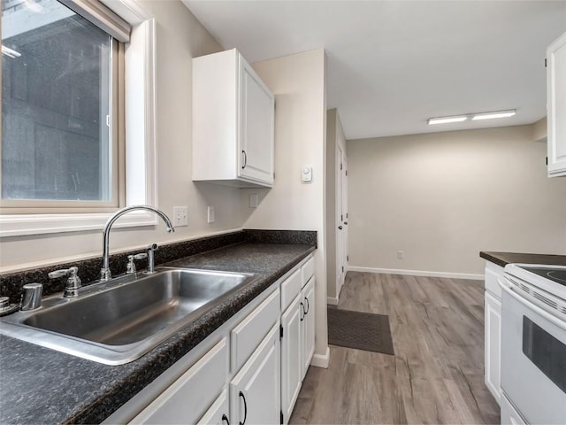 1565 Shadow Run Frontage Unit 104, Steamboat Springs, CO 80487 - kitchen featuring a sink, white electric range oven, light wood-style flooring, white cabinets, and dark countertops