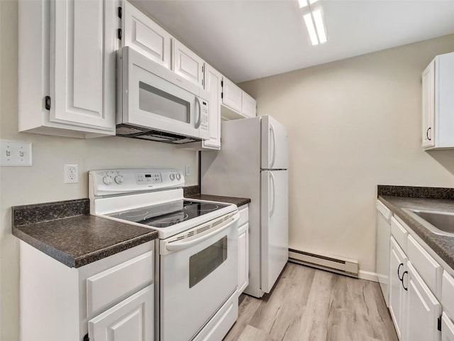 1565 Shadow Run Frontage Unit 104, Steamboat Springs, CO 80487 - kitchen featuring white appliances, baseboard heating, light wood-type flooring, and dark countertops