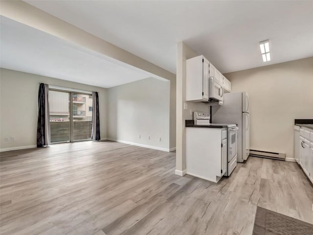 1565 Shadow Run Frontage Unit 104, Steamboat Springs, CO 80487 - kitchen with white appliances, a baseboard radiator, white cabinetry, light wood-style floors, and baseboards