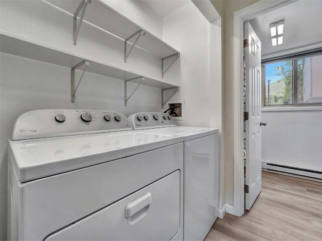 1565 Shadow Run Frontage Unit 104, Steamboat Springs, CO 80487 - laundry area with a baseboard radiator, washing machine and clothes dryer, and light wood-type flooring