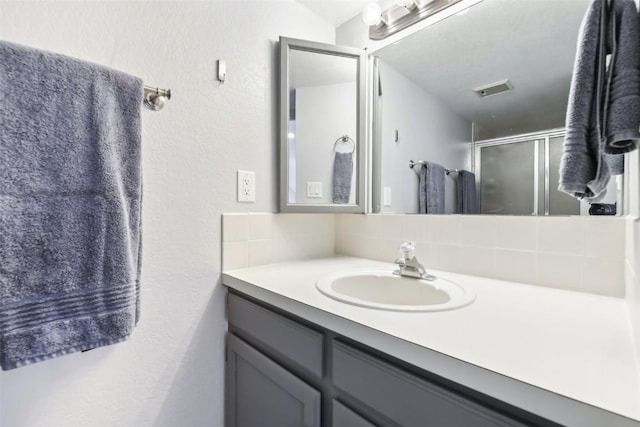 855 S 5th Ave Unit 296, Frisco, CO 80443 - bathroom featuring tasteful backsplash, vanity, a shower stall, and a textured wall