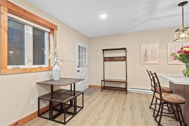 dining space featuring light wood-style flooring and baseboards