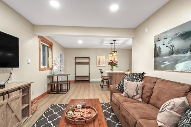 living room with baseboards, recessed lighting, and light wood-style flooring