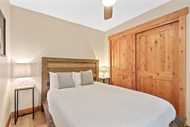 bedroom with ceiling fan, baseboards, and wood finished floors
