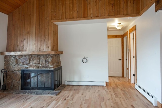 602 Ryan Gulch Rd Unit B, Silverthorne, CO 80498 - unfurnished living room with baseboard heating, a fireplace, wood walls, wood finished floors, and wooden ceiling