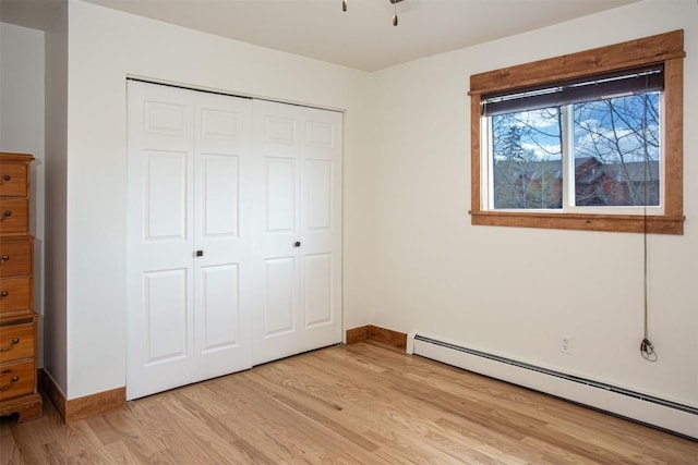 602 Ryan Gulch Rd Unit B, Silverthorne, CO 80498 - unfurnished bedroom featuring a baseboard heating unit, a closet, light wood finished floors, and baseboards