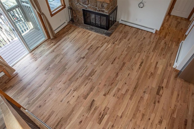 602 Ryan Gulch Rd Unit B, Silverthorne, CO 80498 - unfurnished living room featuring a baseboard radiator, light wood-style floors, a fireplace, and a baseboard heating unit