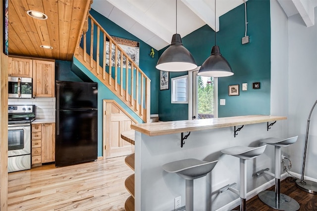 73 Illinois Gulch Rd Unit 8, Breckenridge, CO 80424 - kitchen featuring stainless steel appliances, light wood-style flooring, a kitchen bar, decorative light fixtures, and light countertops