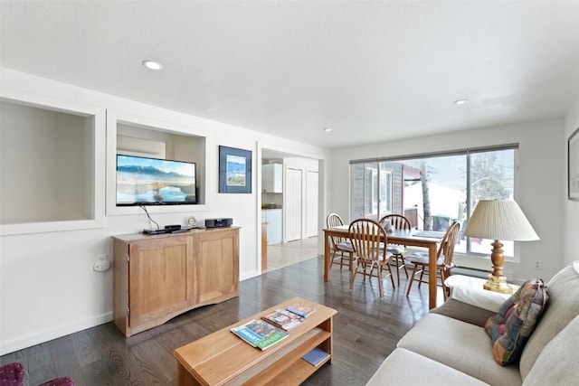 living area with baseboards, dark wood-style flooring, and recessed lighting