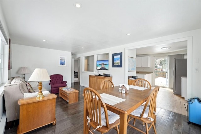 dining space with dark wood-type flooring and recessed lighting