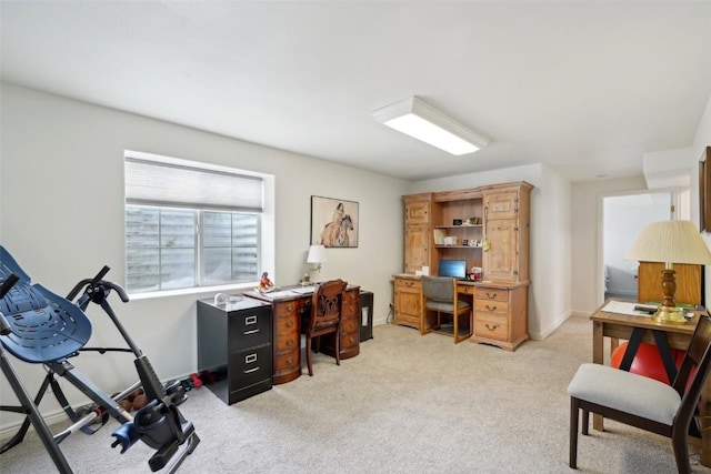 office space with baseboards and light colored carpet