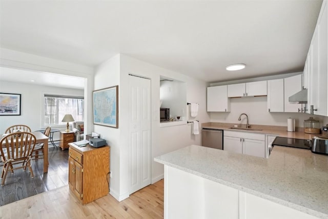 kitchen featuring a sink, dishwasher, exhaust hood, white cabinets, and light stone countertops