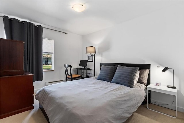 bedroom with a baseboard heating unit and carpet floors