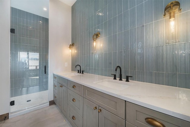 bathroom with a stall shower, a sink, and tile walls