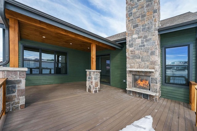 deck with an outdoor stone fireplace
