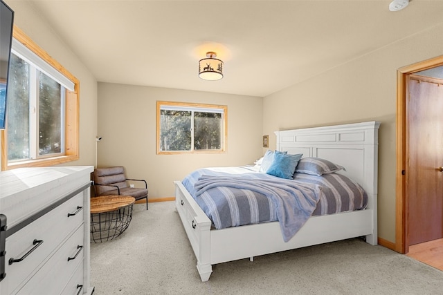 bedroom featuring baseboards and light colored carpet