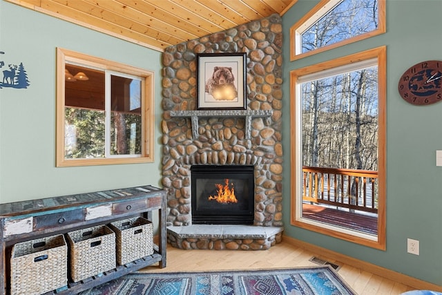 interior space with wood finished floors, a fireplace, wooden ceiling, lofted ceiling, and visible vents