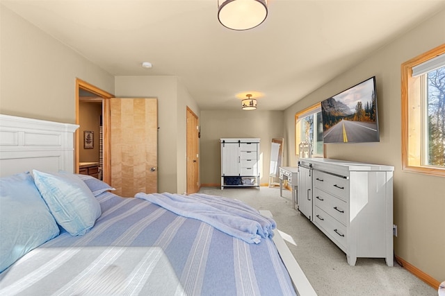 bedroom with light carpet and baseboards