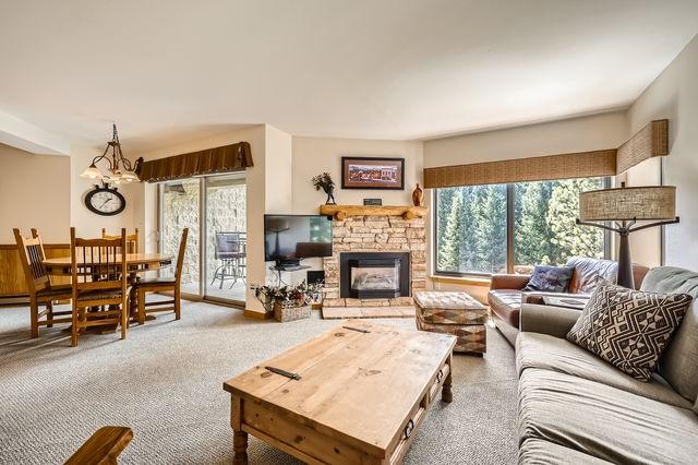 755 Columbine Rd Unit 303, Breckenridge, CO 80424 - living room with plenty of natural light, a chandelier, carpet floors, and a stone fireplace