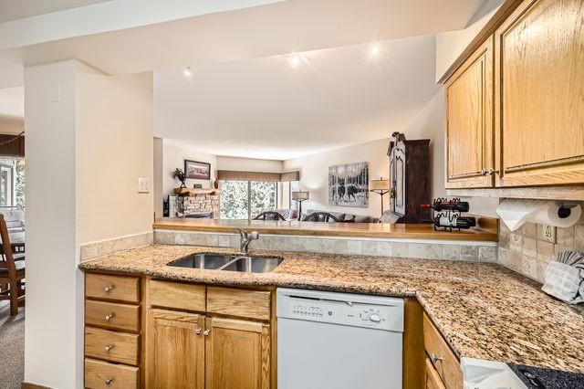 755 Columbine Rd Unit 303, Breckenridge, CO 80424 - kitchen with dishwasher, a sink, light stone counters, and decorative backsplash