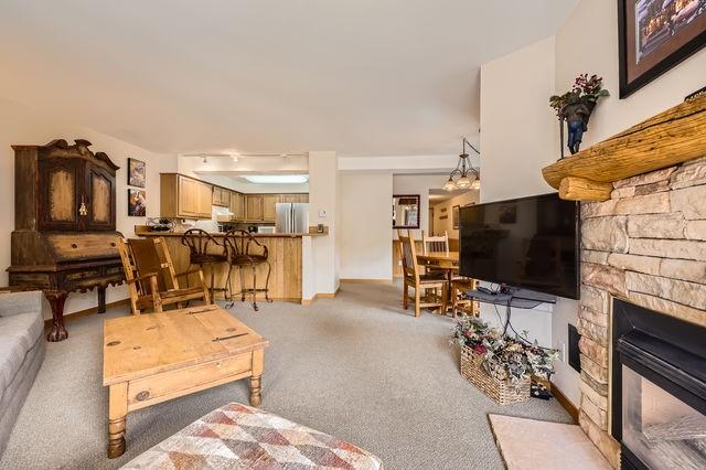 755 Columbine Rd Unit 303, Breckenridge, CO 80424 - living room with light carpet and a stone fireplace