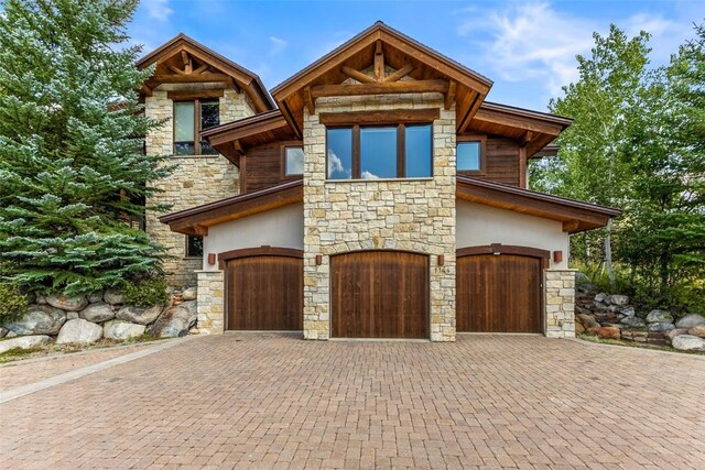 view of front of home with a garage, decorative driveway, and stucco siding