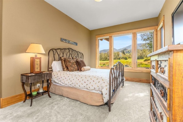 carpeted bedroom with vaulted ceiling and baseboards