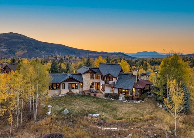 view of front of house with a mountain view and a yard