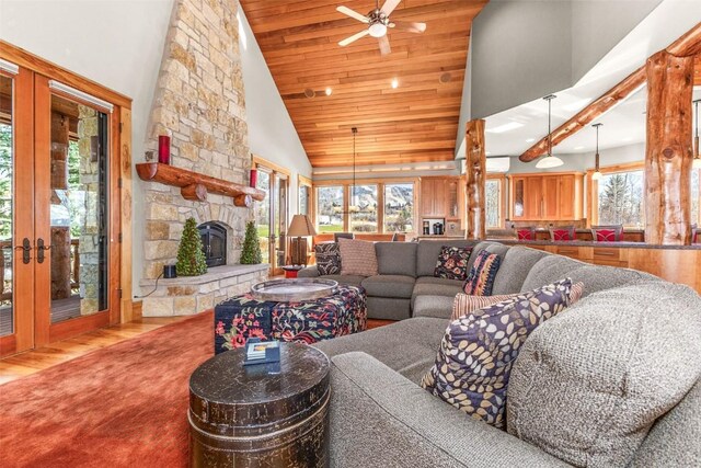 living room with wood ceiling, wood finished floors, an AC wall unit, a fireplace, and high vaulted ceiling