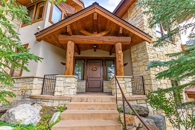 property entrance with stone siding and stucco siding