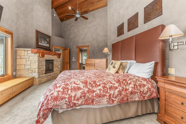 bedroom featuring high vaulted ceiling, wood ceiling, light colored carpet, and a stone fireplace