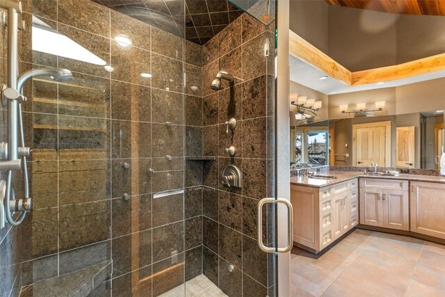 bathroom with tile patterned flooring, a shower stall, and vanity