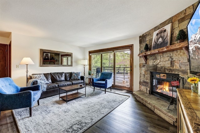 23034 US Highway 6 Unit 203, Dillon, CO 80435 - living room featuring a textured ceiling, hardwood / wood-style flooring, and a stone fireplace