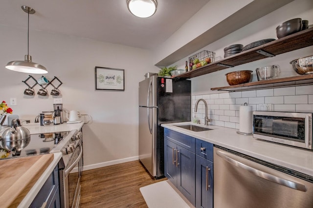 kitchen with a sink, tasteful backsplash, blue cabinetry, open shelves, and appliances with stainless steel finishes