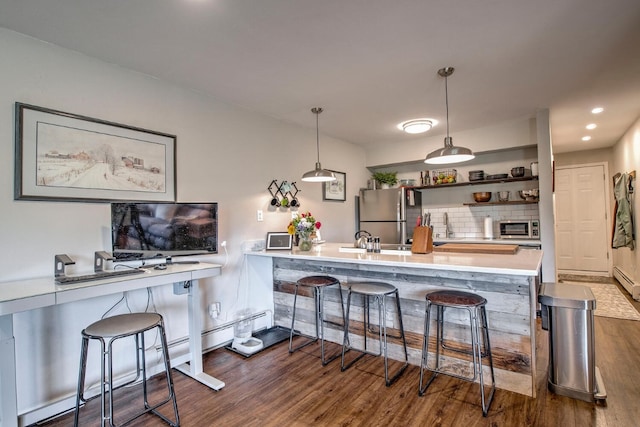 2442 Ryan Gulch Ct Unit 204, Silverthorne, CO 80498 - kitchen with stainless steel appliances, dark wood-style floors, a kitchen breakfast bar, light countertops, and tasteful backsplash