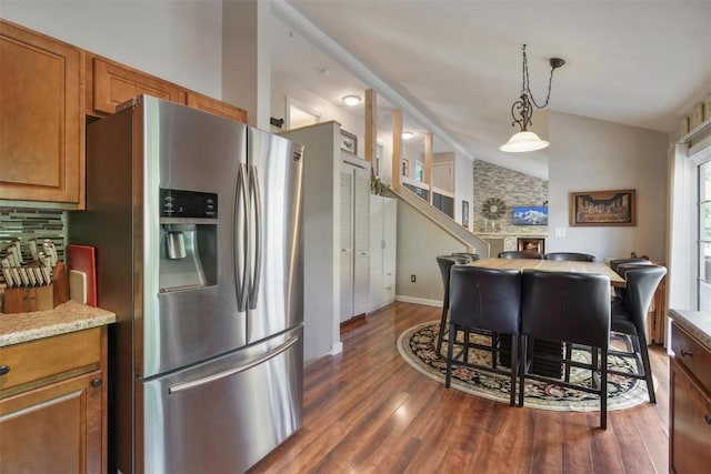 897 Deer Path Rd, Dillon, CO 80435 - kitchen with stainless steel fridge with ice dispenser, dark wood-style floors, brown cabinets, pendant lighting, and lofted ceiling