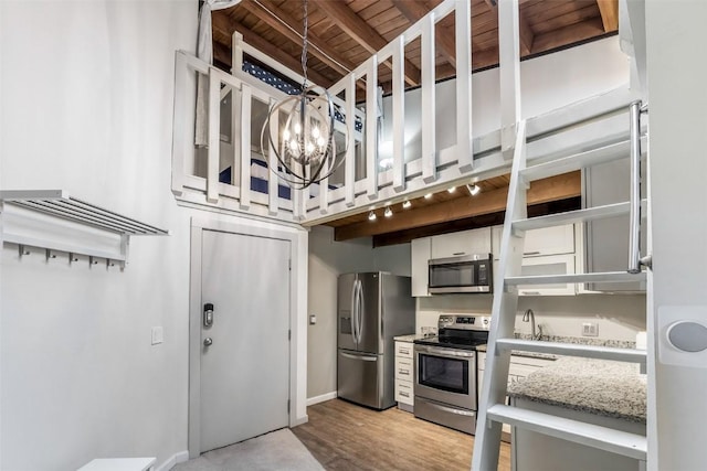 2200 Lodgepole Cir Unit 308, Silverthorne, CO 80498 - kitchen with light wood-type flooring, white cabinets, a chandelier, wooden ceiling, and appliances with stainless steel finishes
