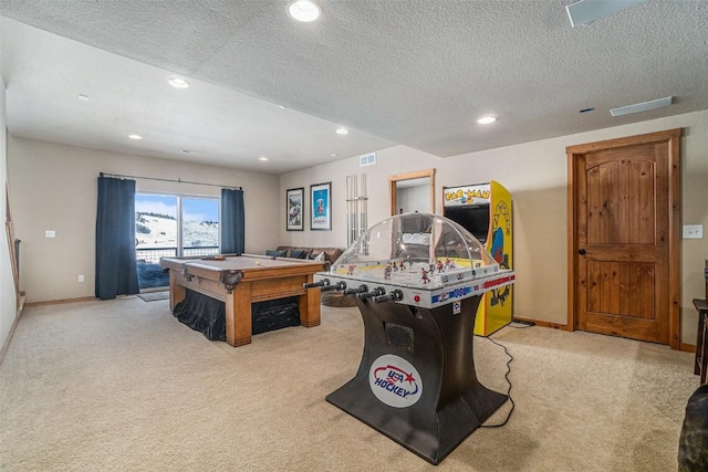 recreation room with light colored carpet and a textured ceiling