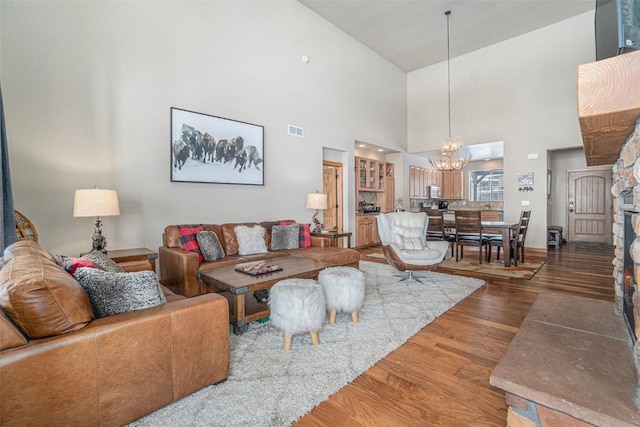 living room featuring a fireplace, dark wood-type flooring, and a chandelier