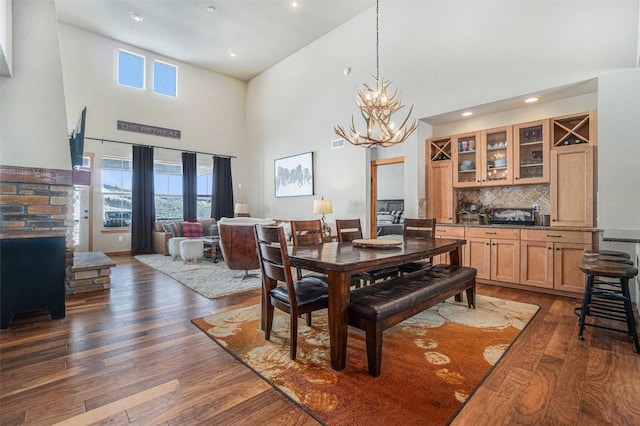 dining room with dark hardwood / wood-style floors, a wealth of natural light, and an inviting chandelier