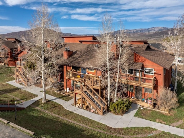 23800 County Road 16 Unit 306, Oak Creek, CO 80467 - view of front of house featuring a chimney, a balcony, a front yard, and a mountain view