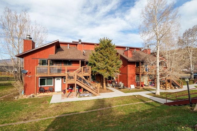23800 County Road 16 Unit 306, Oak Creek, CO 80467 - back of house with a chimney, a patio, stairs, and a lawn