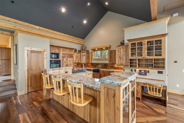 2655 Hunters Knob Rd, Silverthorne, CO 80498 - kitchen with black appliances, high vaulted ceiling, a large island with sink, brown cabinets, and a breakfast bar