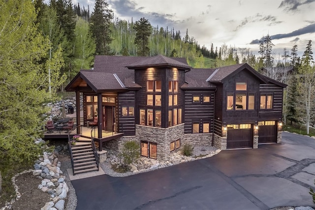 2655 Hunters Knob Rd, Silverthorne, CO 80498 - view of front of property with stone siding, asphalt driveway, an attached garage, stairs, and a wooden deck