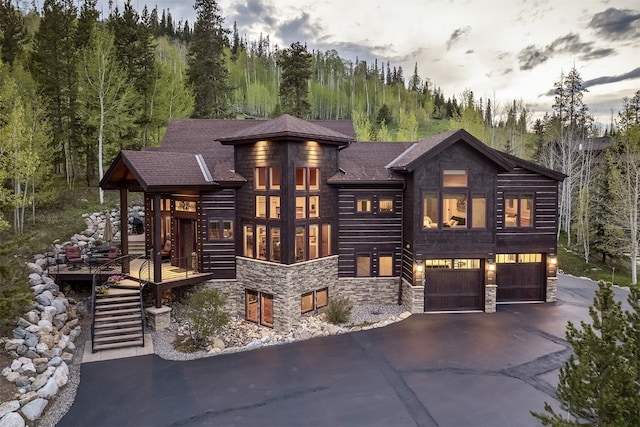 2655 Hunters Knob Rd, Silverthorne, CO 80498 - view of front of property with stone siding, driveway, an attached garage, stairway, and a forest view