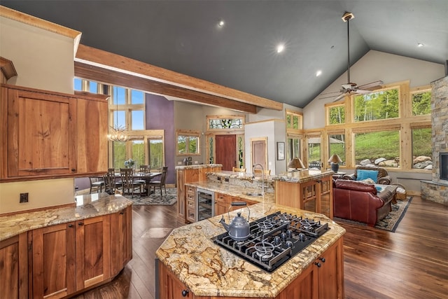 2655 Hunters Knob Rd, Silverthorne, CO 80498 - kitchen with black gas stovetop, open floor plan, brown cabinetry, a large island, and high vaulted ceiling