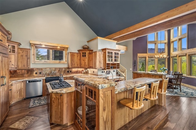 2655 Hunters Knob Rd, Silverthorne, CO 80498 - kitchen with appliances with stainless steel finishes, high vaulted ceiling, an island with sink, dark wood finished floors, and brown cabinets